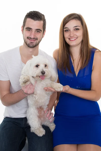 Casal jovem e feliz com seu cão branco amoroso — Fotografia de Stock