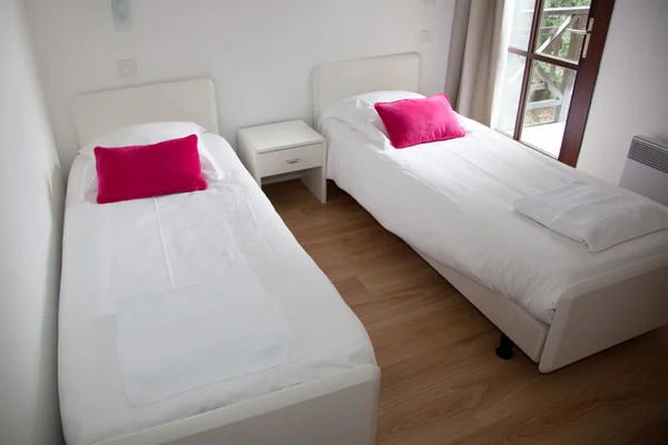 Two single beds in cozy bedroom in a bright house