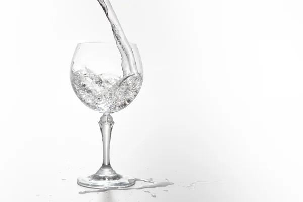 Pouring water on a glass on white background — Stock Photo, Image