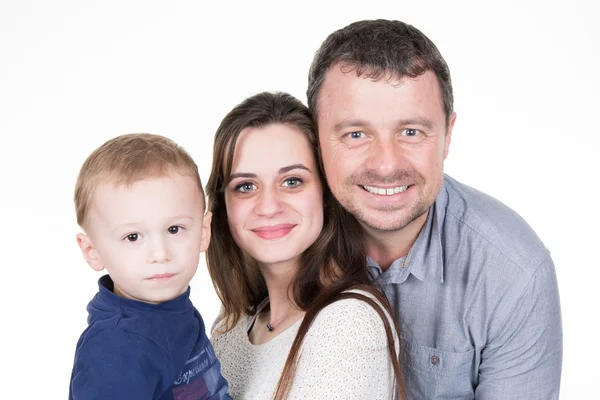 Familia joven y feliz con un niño bonito posando sobre fondo blanco — Foto de Stock