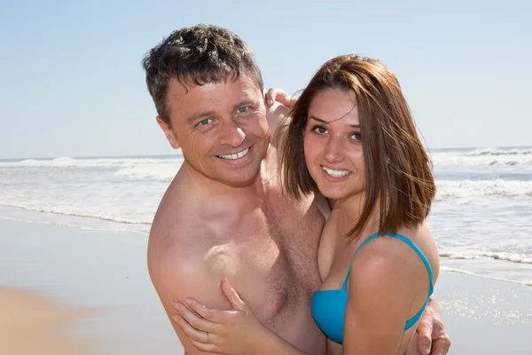 Underbara par njuter på stranden en solig dag — Stockfoto