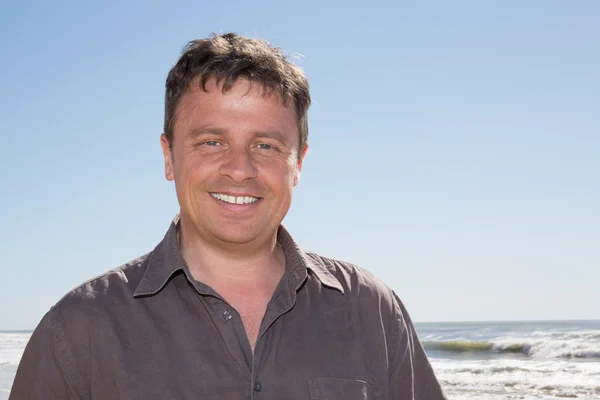 Portrait of rugged middle aged man standing at the beach — Stock Photo, Image