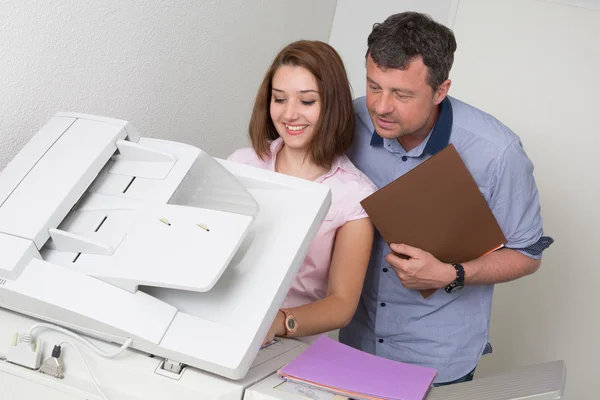 Gente de negocios usando una fotocopiadora en el trabajo — Foto de Stock