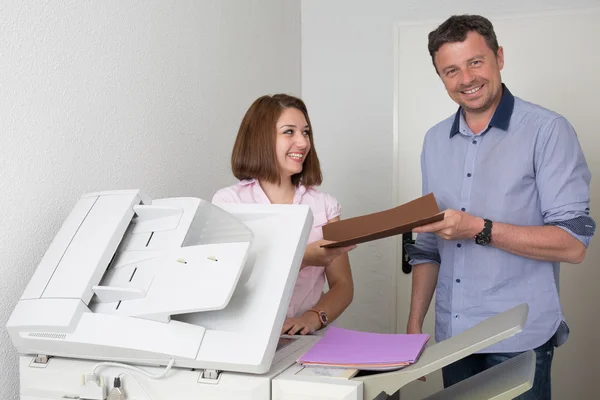 Man och kvinna med en kopieringsmaskin på kontor — Stockfoto