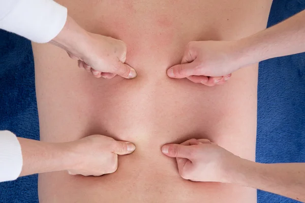 Man getting a massage 2 women, 4 hands — Stock Photo, Image