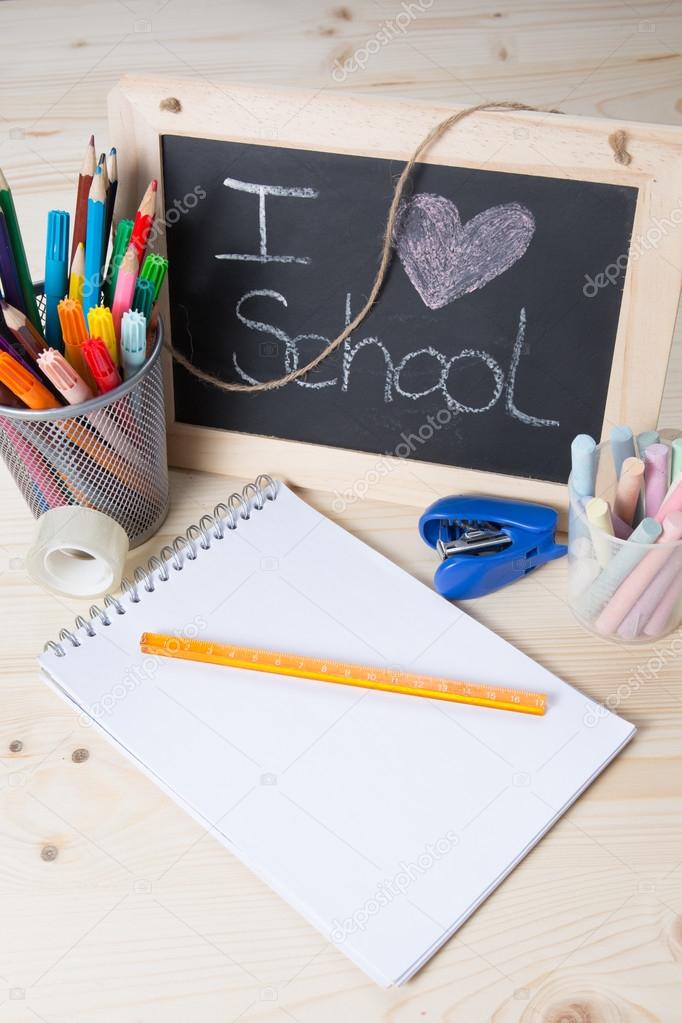 Small school desk with various school supplies closeup Stock Photo by