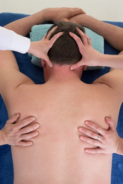 Thai back massage with four hands on the back of the man