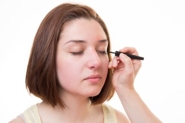 sıvı eyeliner fırçası ile uygulayarak makyöz yakın çekim