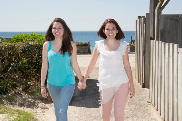 Twee vrolijke meisjes zus of vriend in de straat wandelen — Stockfoto