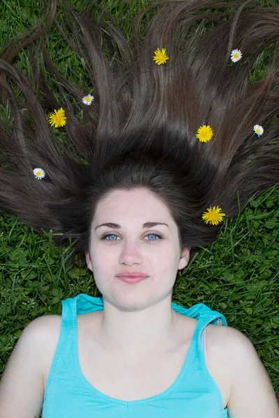 Gyönyörű nő feküdt egy kerti virágok — Stock Fotó