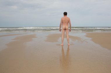 Adam çıplaklar plajında masmavi gökyüzü altında