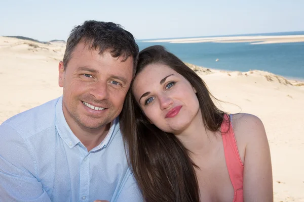 Snygg man och kvinna, leende på stranden — Stockfoto