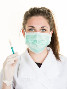 Şırınga tutarak maske ve laboratuvar paltolu kadın doktor.
