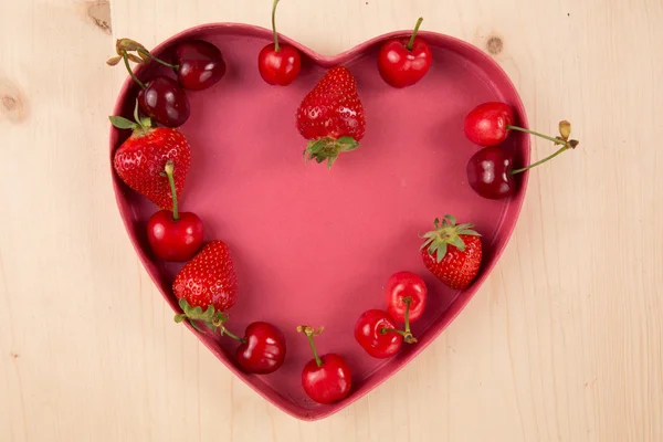 Sevgililer günü için kalp şeklinde kutusunda kırmızı meyveler — Stok fotoğraf