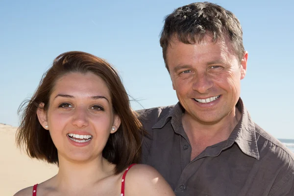 Gülümseyen çift başka bir plajda holding — Stok fotoğraf
