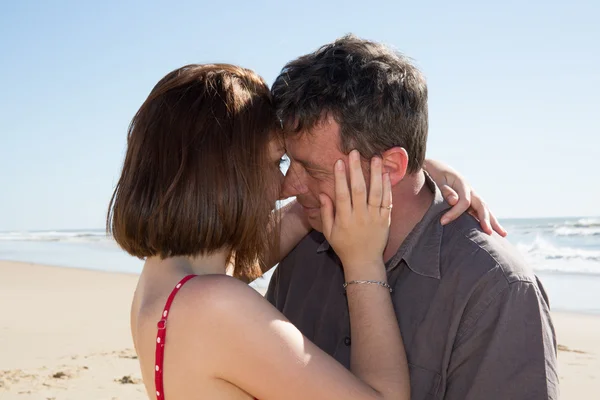 Porträtt av ung man och kvinna kysser på en strand. — Stockfoto