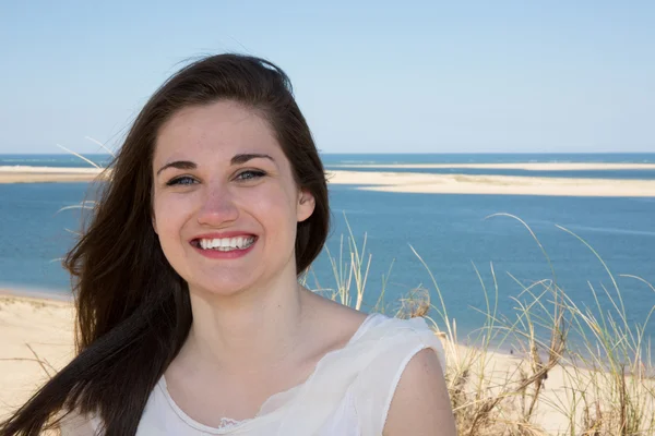 Helles Bild einer glücklich lächelnden Frau am Strand. — Stockfoto