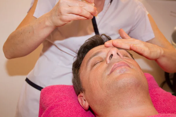 Mann bekommt Gesichts- und Kopfmassage im Wellnesszentrum — Stockfoto
