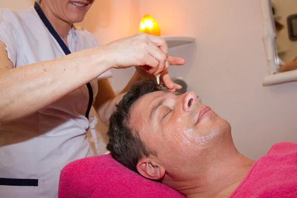 Mann bekommt Gesichts- und Kopfmassage im Wellnesszentrum — Stockfoto