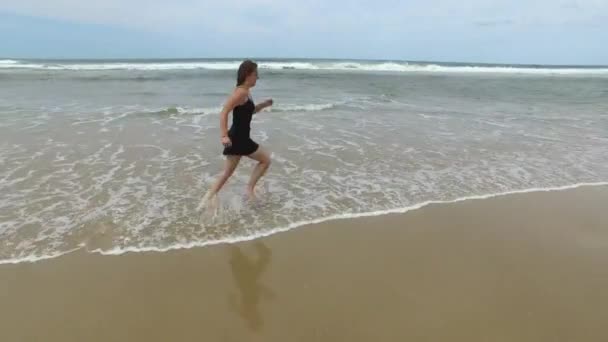 Mulher sozinha andando ao longo da praia — Vídeo de Stock