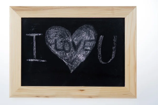 Wooden board for notes in a heart shape with the words white chalk I love you — Zdjęcie stockowe