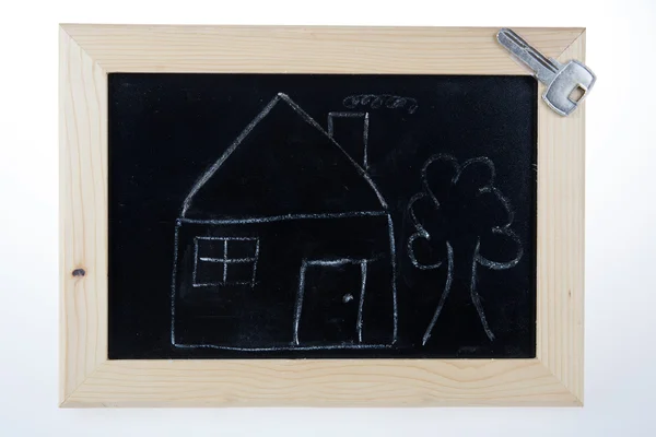 Lustige Skizze eines Hauses mit Baum und Schlüssel auf Tafel — Stockfoto