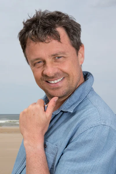 Pensando uomo di mezza età in piedi sulla spiaggia sorridente — Foto Stock