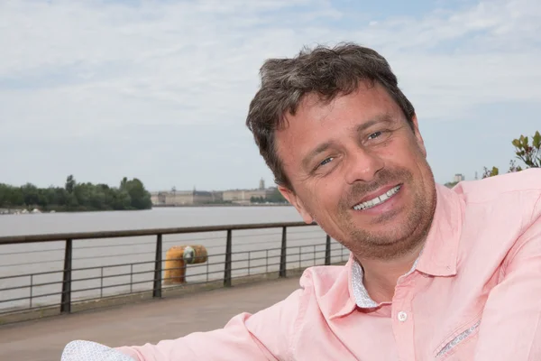Knappe Glimlachende man in roze hemd in lente landschap — Stockfoto