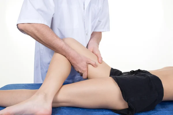 Mani di fisioterapista maschile massaggiare la gamba della femmina — Foto Stock