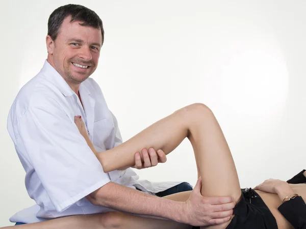Хиропрактик массирует ногу пациентки в физиотерапевтическом кабинете . — стоковое фото