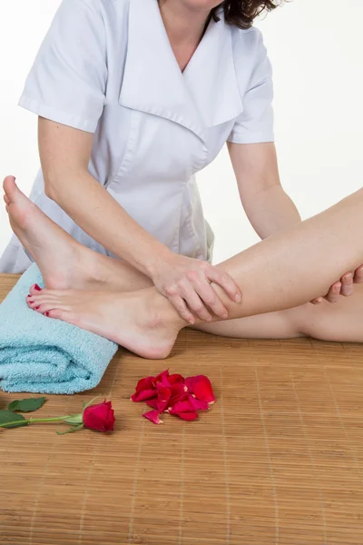 Ruce žena fyzioterapeut kontrolu pacientů nohy na podložku — Stock fotografie