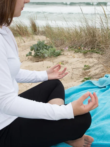 Vrouw mediteren op het strand zitten op het zand — Stockfoto