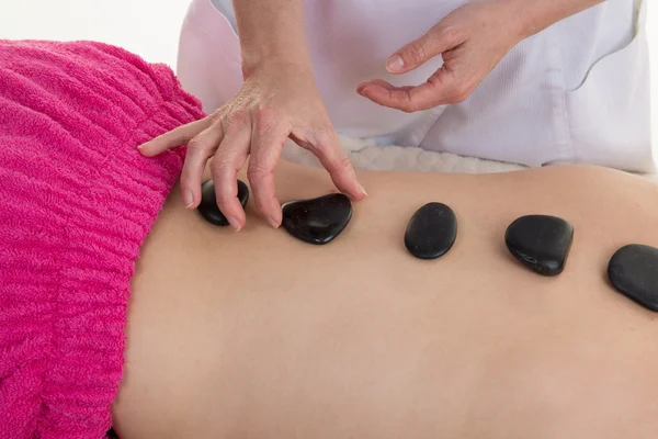 Mujer recibiendo masaje de piedra caliente en el spa, concepto de tratamiento alternativo . —  Fotos de Stock