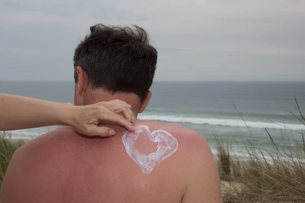 Vrouw handen op iemands rug zetten bescherming tegen de zon zomerdag of lente — Stockfoto