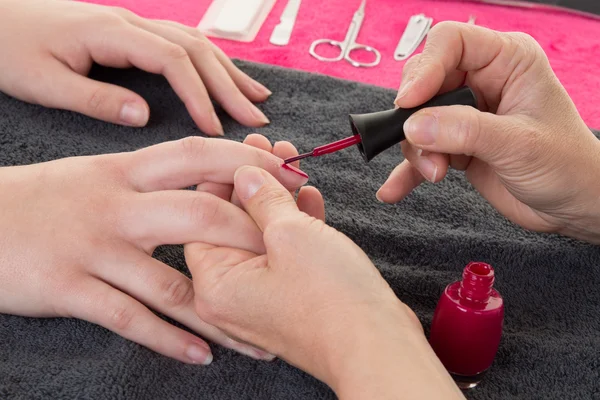 Image of female hands putting a varnish on nails
