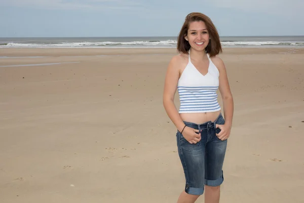 Leende casual kvinna står vid stranden — Stockfoto