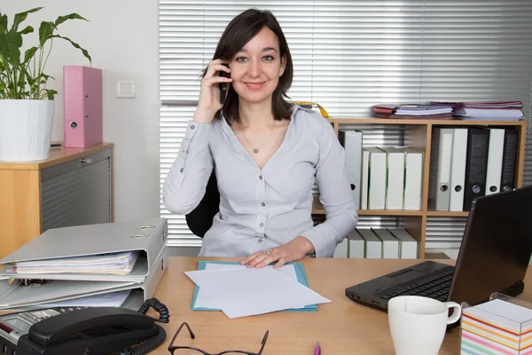 Mujer ocupada hablando en el teléfono inteligente en la oficina — Foto de Stock