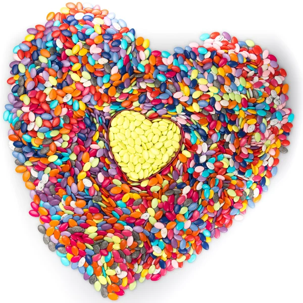 Heart made of colored smarties on a white background. — Stock Photo, Image