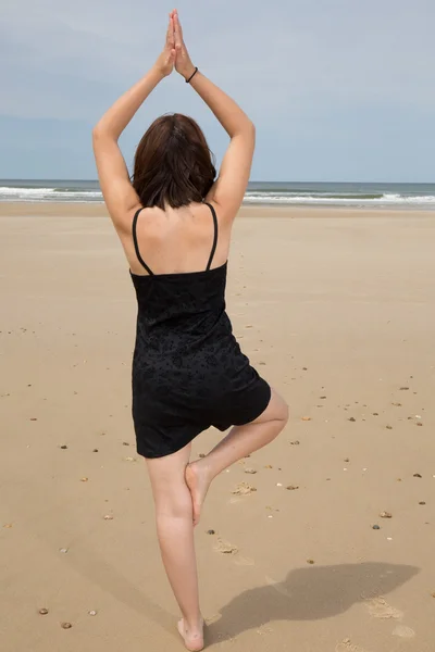 Pohled zezadu na jógu beach žena dělá póza — Stock fotografie