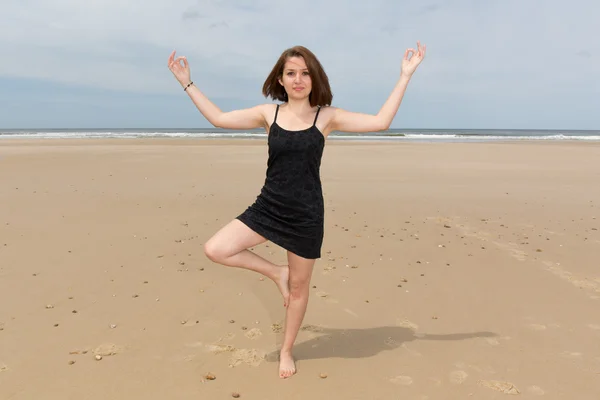 Imagem de uma mulher de praia de ioga fazendo uma pose — Fotografia de Stock