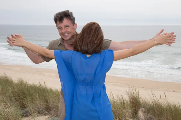 Lyckliga par i kärlek avkopplande på strandsemester njuter av havet — Stockfoto