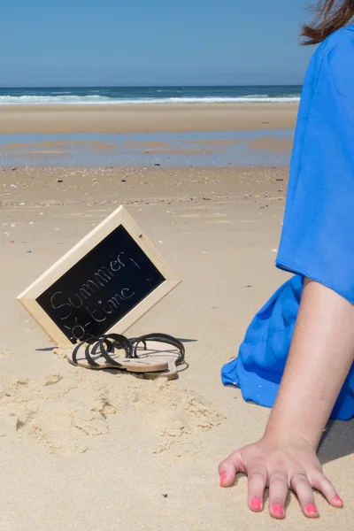 Handen van vrouwenborsten op het strand onder de blauwe hemel — Stockfoto