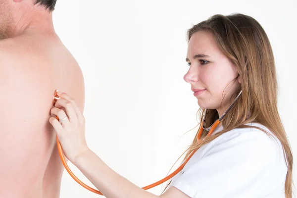 Vista laterale del medico donna esaminare la schiena del paziente con stetoscopio — Foto Stock