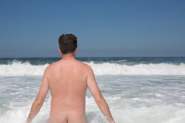 Adam çıplaklar plajında masmavi gökyüzü altında