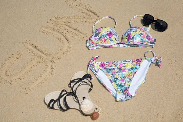 Ordet solen handskriven på sand på stranden, bikini, Glasögon, skor — Stockfoto