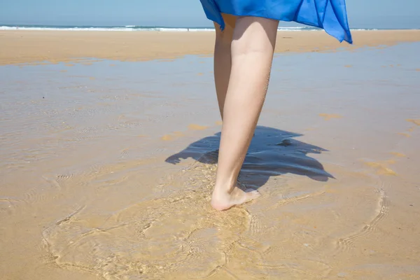 Jonge vrouw loopt alleen op een strand — Stockfoto