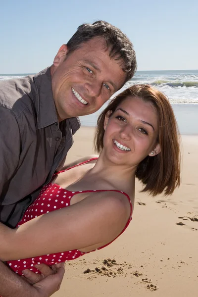 Caucasian man with his wife on the beach having fun — Stock Photo, Image