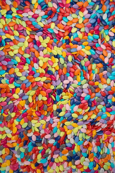 Многоцветные конфеты бонбон (конфеты или шоколадные драже) на заднем плане — стоковое фото