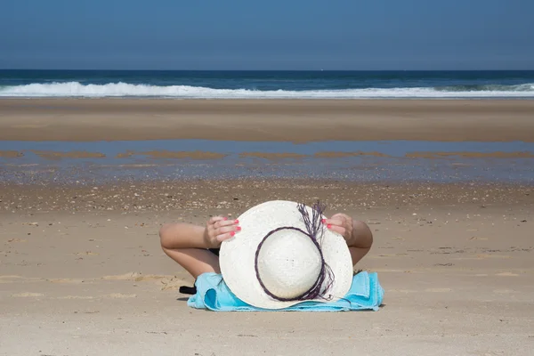 Meisje ligt op het witte zand op het strand-symbool van vakantie — Stockfoto