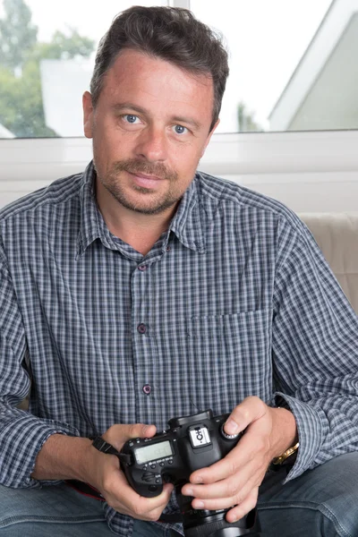 Aantrekkelijke Glimlachende man ontspannen thuis met behulp van camera — Stockfoto